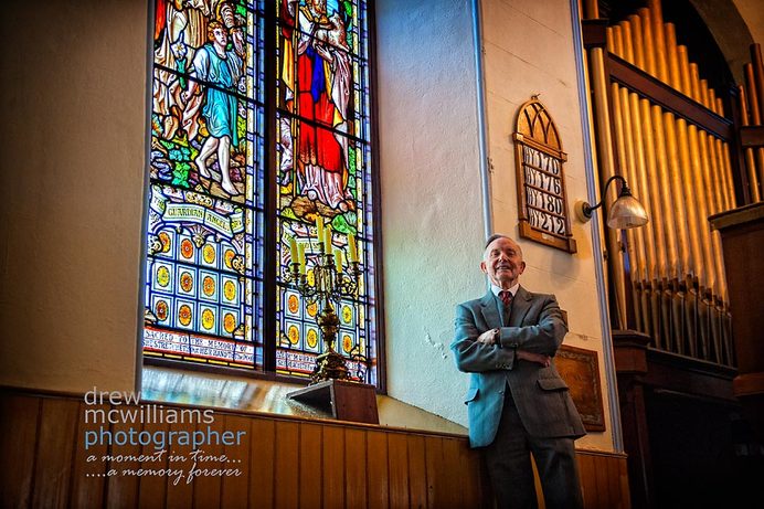Ernie Martin in Dromore Non-subscribing Church beside one of the stained glass windows